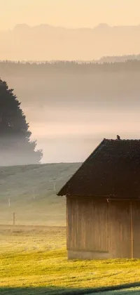 This phone live wallpaper depicts a beautiful barn sitting on a lush green field at dawn