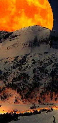 This stunning live wallpaper for your phone features a picturesque scene of a full moon rising over a snowy mountain