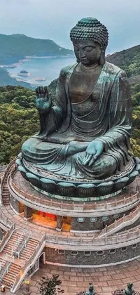 This lively phone live wallpaper showcases a breathtaking vista of a towering statue perched atop a verdant hillside alongside a traditional Chinese building
