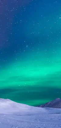 This live wallpaper for your phone showcases a winter landscape with two individuals on top of a snow-covered slope