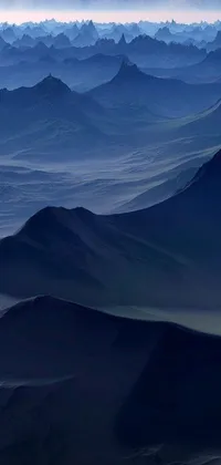 This phone live wallpaper depicts a breathtaking mountain range with a full moon in the sky against a dark desert background