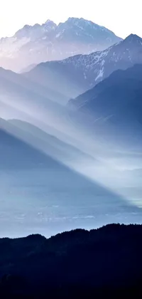 This live wallpaper displays a breathtaking view of mountains from atop a hill