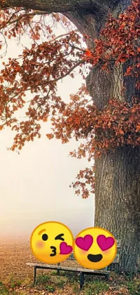 This live wallpaper showcases two emoticons sitting on a bench in front of an oak tree during late autumn