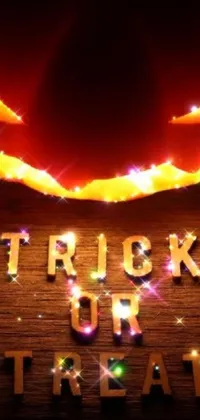 This Halloween-themed phone live wallpaper features a wooden sign with the words "Trick or Treat" that glow in some areas