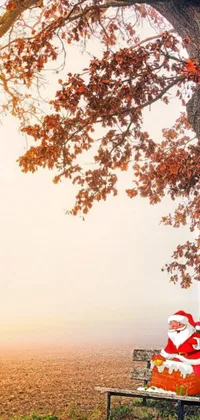 This stunning phone live wallpaper features a serene landscape with a tree and a bench, surrounded by autumn foliage, perfect to add a touch of elegance to your phone screen