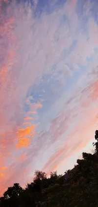 This stunning live phone wallpaper features a clock tower perched on a lush green hill, as a vibrant red and pink-hued sunset paints the sky