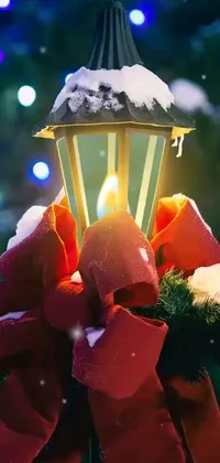 This live wallpaper features a digital art depiction of a lit candle in front of a beautiful Christmas tree with snow-covered, colorful red and green ornaments hanging from its branches