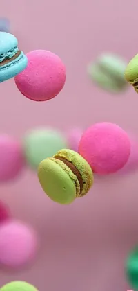 This phone live wallpaper features vibrant macarons in various colors and sizes floating against a soft pastel background