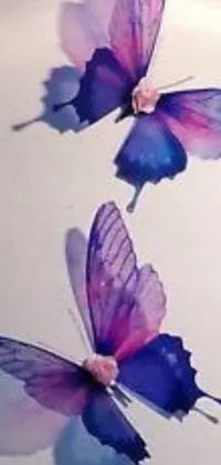 This live wallpaper features three purple and blue butterflies on a white surface, with purple and pink flowers in the background
