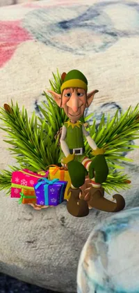 This phone live wallpaper features a delightful cartoon elf perched atop a vibrant pile of wrapped presents