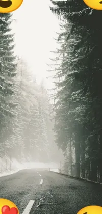 This phone live wallpaper features a group of colorful emoticons sitting on the side of a lush winter forest road