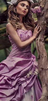 This stunning phone live wallpaper features a beautiful woman in a purple dress leaning against a tree