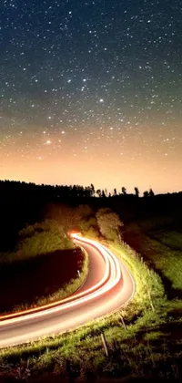 This phone live wallpaper features a gorgeous long exposure photograph of a hilly road at night, complemented by a stunning digital art design