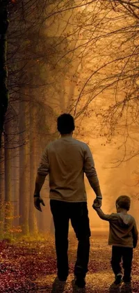 This phone live wallpaper depicts a man and a child strolling down a forest path in the glow of a golden sunset
