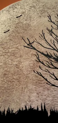 This phone live wallpaper showcases a beautifully detailed silhouette of a tree and full moon with an intricate carpet design in the background