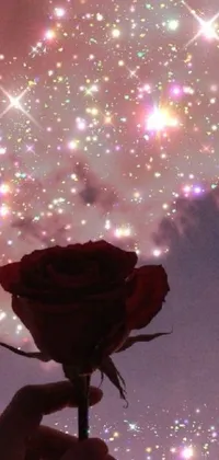 This phone live wallpaper depicts a stunning digital art that showcases a person holding a red flower against a starry night sky