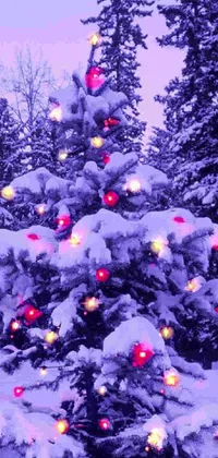 Enjoy the Christmas spirit with this stunning phone live wallpaper featuring a glowing Christmas tree adorned with red and yellow lights amidst a snowy landscape