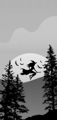 This live phone wallpaper displays a black and white image of a witch flying on a broomstick in a misty forest, with a vintage MacPaint filter for added style