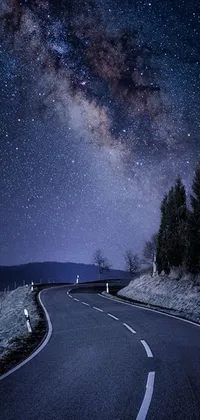 Looking for a stunning live wallpaper for your phone? Check out this gorgeous curved road at night with the milky way in the background! This beautiful space art from Tumblr features breathtaking random images of the night sky strewn with stars and a hilly road with street lights, topped with a car driving with its headlights beaming