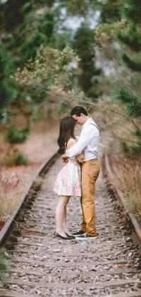 This live wallpaper showcases a cute couple standing on a railroad track set in a lovely rustic environment