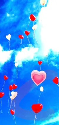 This phone live wallpaper showcases red and white balloons floating in the blue sky with a heart at its center