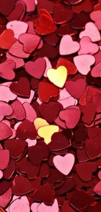 This stunning phone wallpaper features a charming collection of red and pink heart shaped confetti, complemented by a gorgeous picture in gold and red metal