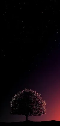 This exquisite phone live wallpaper features a majestic lone tree atop a hill against a starry night sky, with a captivating big pink sphere in the background