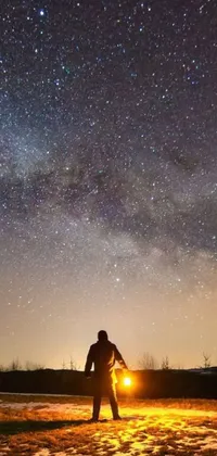 This stunning live wallpaper features a snow-covered field, with a clear night sky adorned with twinkling stars and the Milky Way nebula