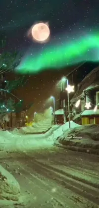 This phone live wallpaper depicts a snowy residential street with Christmas lights and decorations under a full moon sky