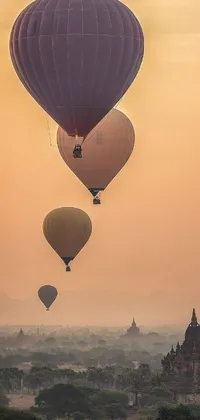 This phone live wallpaper depicts a group of vibrant hot air balloons floating in the sky above a dreamy pale beige backdrop