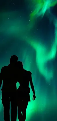 This stunning live wallpaper depicts a couple gazing at the mesmerizing green, blue, and red hues of the northern lights