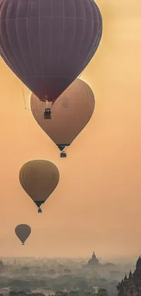 This phone live wallpaper showcases a group of hot air balloons flying above a cityscape