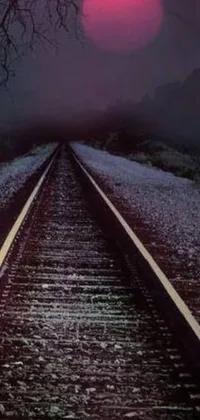 This phone live wallpaper features a train track against a sunset, in a dark ambient album cover style