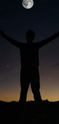 This live wallpaper showcases a man standing amidst a star-lit sky with the full moon in the background