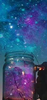 This live wallpaper features a hand holding a mason jar filled with purple and blue liquid that creates a captivating swirling effect