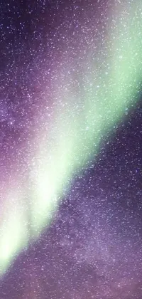 This live phone wallpaper features an eye-catching green and purple aurora borealis against a dark sky