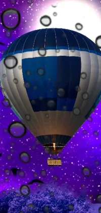 This live phone wallpaper features a colorful hot air balloon floating through a purple sky