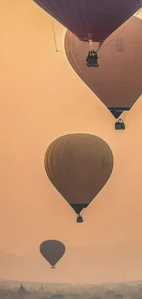 This live wallpaper showcases a captivating image of a group of hot air balloons floating amidst a serene and peaceful beige mist