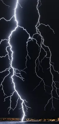 This phone live wallpaper depicts a thunderstorm over a body of water, with a stunning depiction of a lightning bolt and electricity arcs