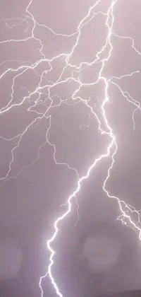 This live smartphone wallpaper features breathtaking lightnings in the sky with glowing white veins pulsating and shimmering against a dark background