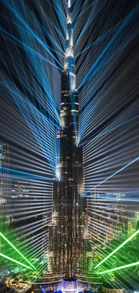 This live wallpaper showcases a tall futuristic building illuminated by multiple lights in Dubai