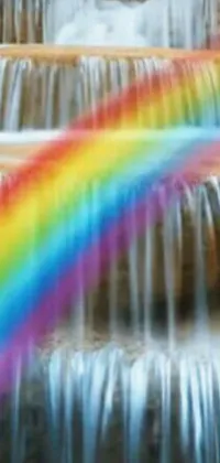 This live wallpaper showcases a mesmerizing waterfall with a rainbow emerging from it