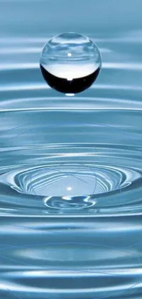 The phone live wallpaper showcases a picturesque scene of a water droplet falling into a serene body of water