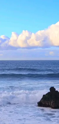 This live wallpaper features an electrifying image of a surfer expertly riding a wave in the midst of an ocean and rock landscape