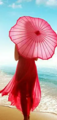 This phone live wallpaper showcases a serene beach scene with a woman holding a bright pink umbrella