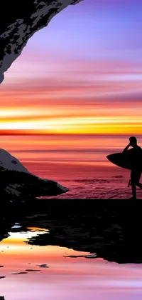 This phone wallpaper features a stunning image of a solitary surfer holding a board, gazing out into the water