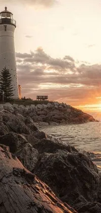 Get transported to a picturesque beach with a breathtaking lighthouse in this stunning phone live wallpaper