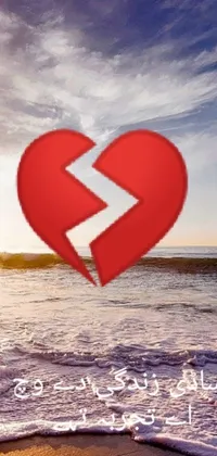 This phone live wallpaper features a striking red heart set against a picturesque beach setting with the ocean in the background, evoking a sense of peacefulness and longing