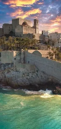 This live phone wallpaper depicts a majestic castle atop a rugged seaside cliff