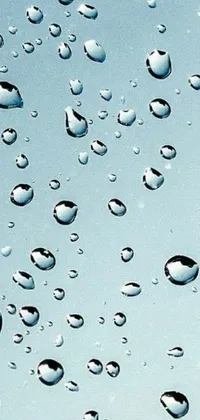 This live phone wallpaper showcases a mesmerizing image of water droplets on a window